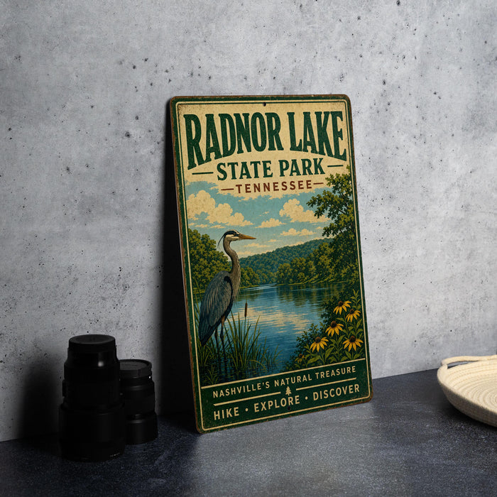 A vintage-style metal sign for Radnor Lake State Park in Tennessee, featuring a scenic illustration of a heron and a lake surrounded by trees.