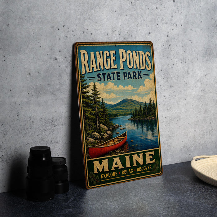 A vintage-style metal sign for Range Ponds State Park in Maine, featuring a scenic image of a lake with a red canoe and pine trees.