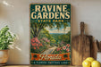 A vintage-style sign for Ravine Gardens State Park in Florida, featuring a scenic illustration of a winding path surrounded by lush greenery and colorful flowers.