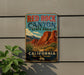 A vintage-style metal sign for Red Rock Canyon State Park in California, featuring a scenic illustration of the canyon and desert landscape.