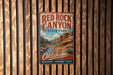 A vintage-style metal sign for Red Rock Canyon State Park in Oklahoma, featuring a scenic illustration of the canyon landscape.