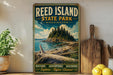 A vintage-style metal sign for Reed Island State Park in Washington, featuring a scenic landscape with a rocky island, pine trees, and a body of water.