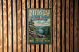 A vintage-style metal sign for Reeds Gap State Park in Pennsylvania, featuring a scenic mountain landscape with pine trees and a lake.