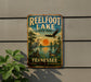 A vintage-style sign for Reelfoot Lake State Park in Tennessee, featuring an illustration of a bird, a duck, and a sunset over the lake.