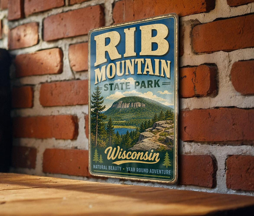 A vintage-style metal sign for Rib Mountain State Park in Wisconsin, featuring a scenic mountain landscape with pine trees and a lake.