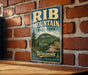 A vintage-style metal sign for Rib Mountain State Park in Wisconsin, featuring a scenic mountain landscape with pine trees and a lake.