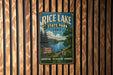 A vintage-style metal sign for Rice Lake State Park in Iowa, featuring a scenic landscape with a river, trees, and a sign indicating the park's name.