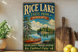 A vintage-style poster advertising Rice Lake State Park in Minnesota, featuring a scenic image of a lake, pine trees, and a canoe.