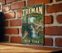 A vintage-style metal sign for Robert H. Treman State Park in New York, featuring a scenic image of a waterfall surrounded by lush greenery.
