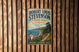 A vintage-style metal sign for Robert Louis Stevenson State Park, California, featuring a scenic landscape with mountains, a river, and a path leading to the park.