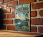A vintage-style metal sign for Robert Moses State Park, New York, featuring a scenic illustration of the park's natural surroundings.