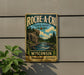 a vintage-style metal sign for Racine, Wisconsin, with a scenic illustration of a river and forest.
