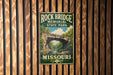 A vintage-style metal sign for Rock Bridge Memorial State Park in Missouri, featuring a scenic illustration of the bridge and surrounding landscape.