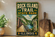 A vintage-style sign for Rock Island Trail State Park in Illinois, featuring a scenic illustration of a bridge and a river surrounded by lush greenery.