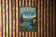 A vintage-style metal sign for Rockport State Park in Washington, featuring a scenic landscape with a bridge and mountains in the background.
