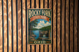 A vintage-style metal sign for Rocky Fork State Park in Ohio, featuring a scenic landscape with a lake and trees.