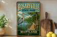 A vintage-style metal sign for Rosaryville State Park in Maryland, featuring a heron and a wooden boardwalk.
