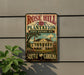 A vintage-style sign for Rose Hill Plantation, a historic site in South Carolina, featuring a large illustration of a plantation house surrounded by lush greenery.