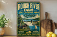 A vintage-style sign for Rough River Dam State Resort Park in Kentucky, featuring a scenic illustration of a dam, cabin, and boats.