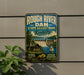 A vintage metal sign for Rough River Dam State Resort Park in Kentucky, featuring a scenic illustration of a dam, cabin, and sailboat.
