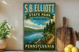 A vintage-style sign for S.B. Elliott State Park in Pennsylvania, featuring a scenic landscape with a lake and forest.