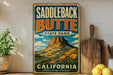 A vintage-style metal sign for Saddleback Butte State Park in California, featuring a mountain landscape and the text "Saddleback Butte State Park California Adventure Awaits!"
