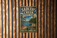 A vintage metal sign for Sadlers Creek State Park in South Carolina, featuring a scenic landscape with a lake and forest.