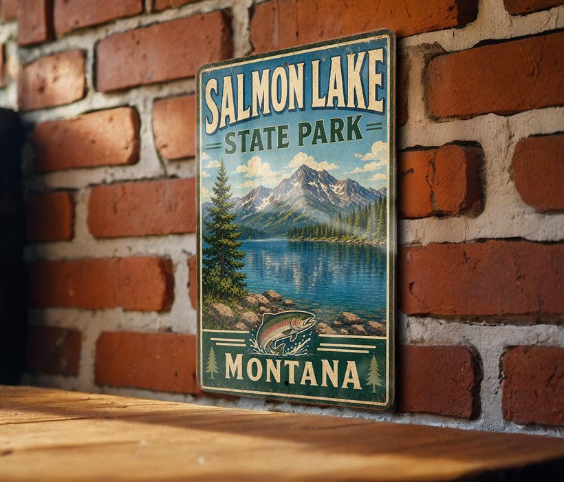 A vintage metal sign for Salmon Lake State Park in Montana, featuring a scenic landscape with mountains, a lake, and a pine tree.