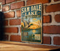 A vintage metal sign for Sam Dale Lake, featuring an illustration of a duck in flight over a scenic landscape.