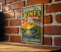 A vintage-style metal sign for Sam Houston Jones State Park in Louisiana, featuring a scenic illustration of a sunset over a body of water with palm trees.