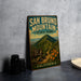 A vintage-style metal sign for San Bruno Mountain State Park in California, featuring a scenic mountain landscape and a trail sign.