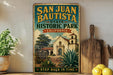 A vintage-style sign for San Juan Bautista State Historic Park in California, featuring an illustration of a historic building and a cactus plant.