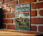 A vintage-style metal sign for San Marcos Apalache Historic State Park in Florida, featuring an illustration of a historic building and palm trees.