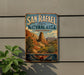 A vintage-style metal sign for San Rafael State Natural Area in Arizona, featuring a desert landscape with mountains and desert plants.