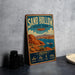 A vintage-style sign for Sand Hollow State Park in Utah, featuring a scenic illustration of the park's landscape with a lake and mountains in the background.