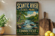 A vintage-style sign for Scantic River State Park in Connecticut, featuring a scenic image of a river surrounded by trees and mountains.