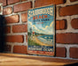 A vintage-style metal sign for Scarboro Beach, Maine, featuring a beach scene with a lifeguard chair and ocean waves.