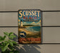 A vintage metal sign for Scusset Beach, Massachusetts, featuring a lighthouse and beach scene.