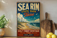 A vintage-style metal sign for Sea Rim State Park in Texas, featuring a lighthouse and beach scene, is displayed on a shelf next to a wooden cutting board and some lemons.