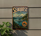 A vintage metal sign for Sequest State Park, featuring a scenic landscape with mountains, a river, and a submarine, mounted on a wall.