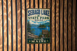 A vintage metal sign for Sebago Lake State Park in Maine, featuring a scenic image of the lake and surrounding landscape.