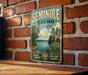 A vintage-style metal sign for Seminole State Park, Georgia, featuring a scenic landscape with a lake, palm trees, and a rocky cliff.