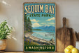 A vintage-style sign for Sequim Bay State Park, featuring a scenic landscape with mountains, pine trees, and a lake.