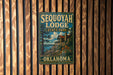 A vintage metal sign for Sequoyah Lodge, a state park in Oklahoma, is displayed on a wooden wall.