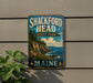 A vintage metal sign for Shackford Head State Park in Maine, featuring a scenic landscape with cliffs, pine trees, and a body of water.