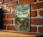 A vintage metal sign for Shawme-Crowell State Forest in Massachusetts, featuring a scenic image of pine forests and a lake.