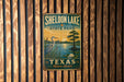 A vintage metal sign for Sheldon Lake State Park in Texas, featuring a seagull and a water lily, mounted on a wooden wall.