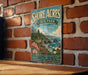 A vintage-style metal sign for Shore Acres State Park in Oregon, featuring a scenic coastal landscape with cliffs, flowers, and a body of water.