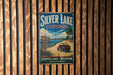 A vintage metal sign for Silver Lake State Park, featuring a scenic image of a jeep on a dirt road with a lake in the background.