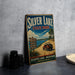 A vintage-style sign for Silver Lake State Park, featuring a scenic image of a jeep on a dirt road with a lake in the background.